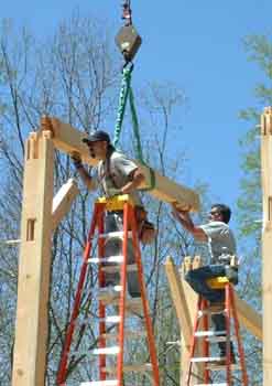Second floor girt being set at top of posts.
This photo shows a girt being set at the top of two post.
