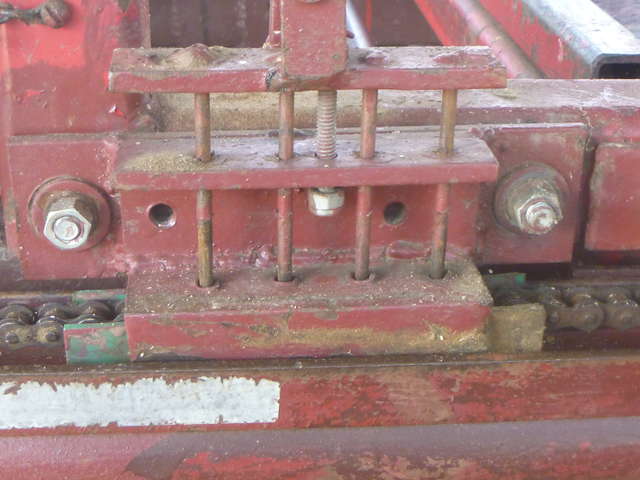 A 4-fingered clutch mounted on the sawhead carriage inserts 4 nails between the chain rollers to drive the sawhead. (Disengaged position)
